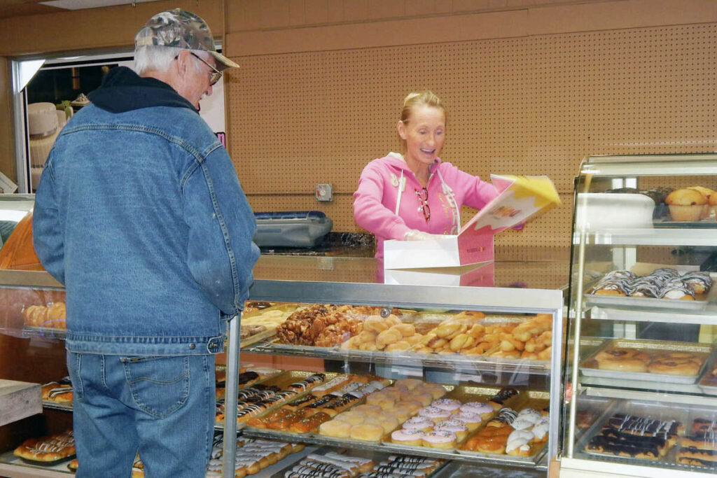 Kim happily serving customer at Kim's OTHER place with yummy donuts and pastries -Kim's Place Café - Jacksonville, IL